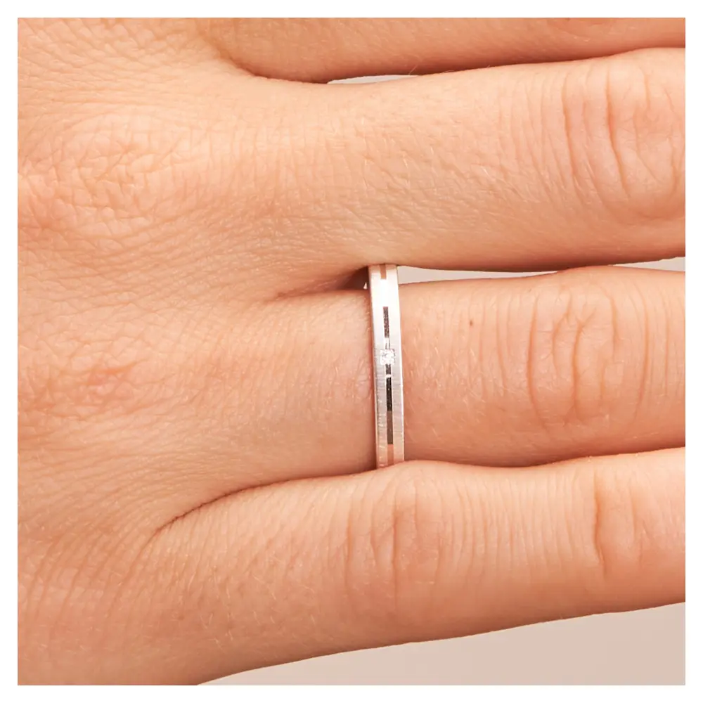 Ehering aus Weißgold quermatt schmal mit Diamanten und polierter Mittelrille auf Hand im Zoom