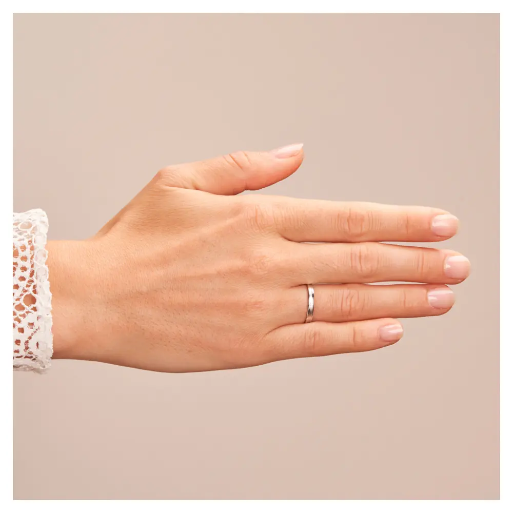 Eheringe aus Platin mit Diamanten in sandmattierter Rille auf Hand