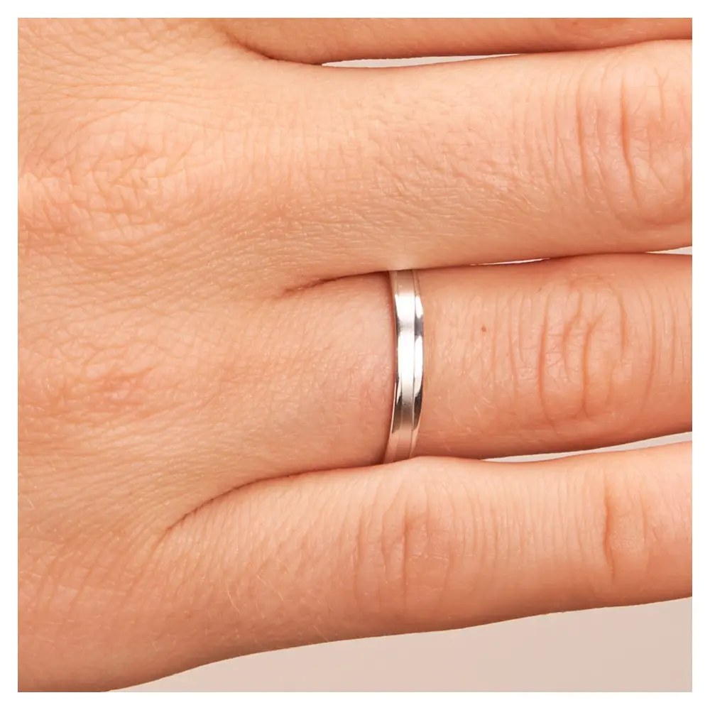 Eheringe aus Platin mit sandmattierter Rille auf Hand im Zoom
