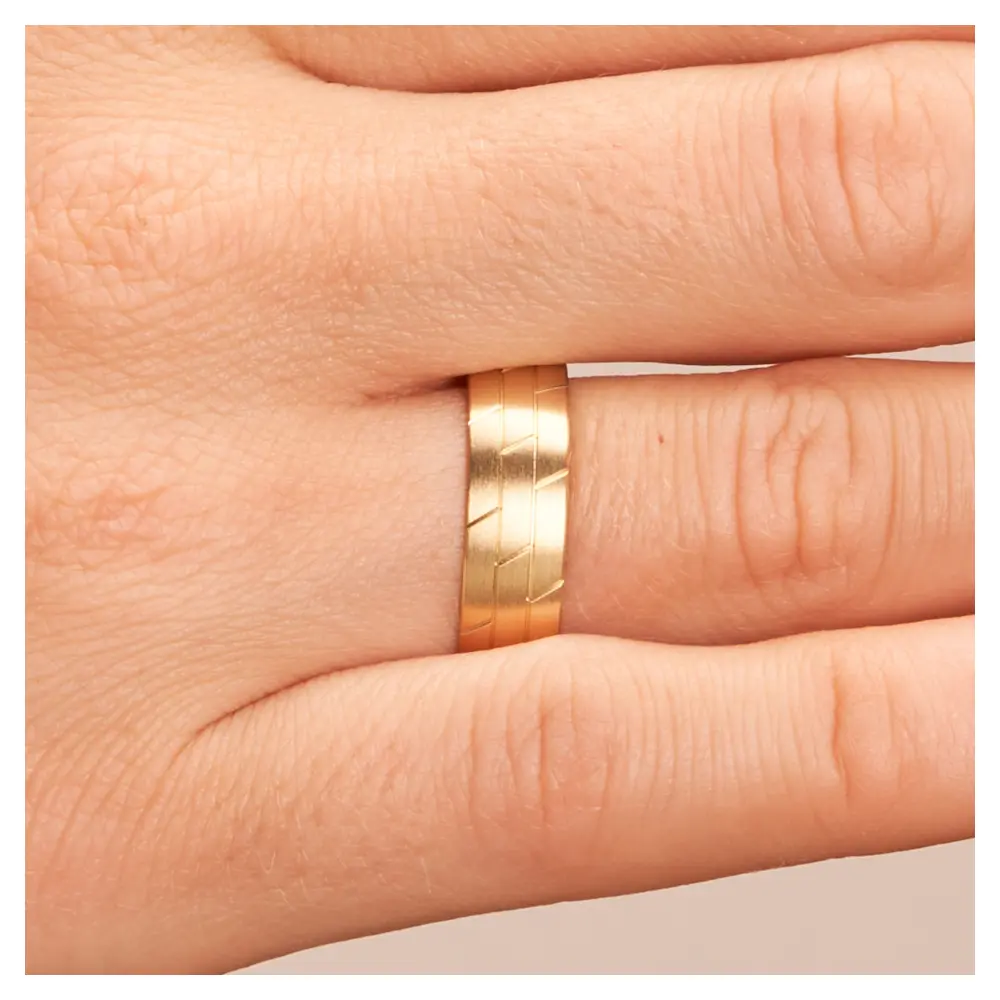Gelbgold Ehering mit geometrischem Muster und Mattierung auf Hand im Zoom