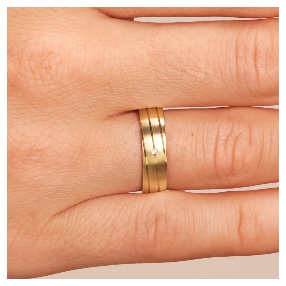 Gelbgold Trauring matt mit Rillen und Diamanten auf Hand im Zoom