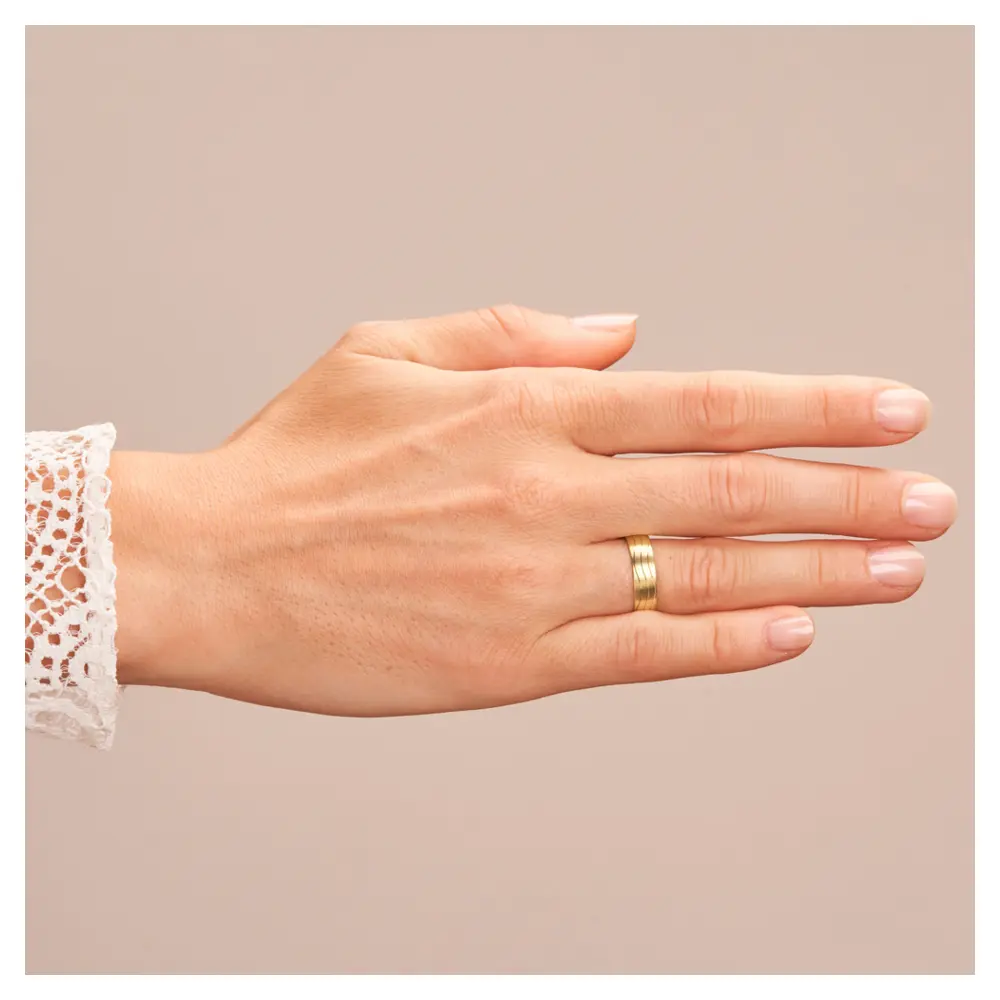 Trauring in Gelbgold matt mit Wellenmuster auf Hand