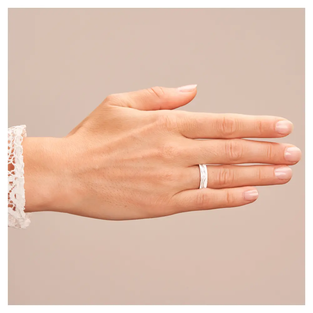 Strukturierter Weissgold Trauring mit Diamant und polierten Rillen auf Hand
