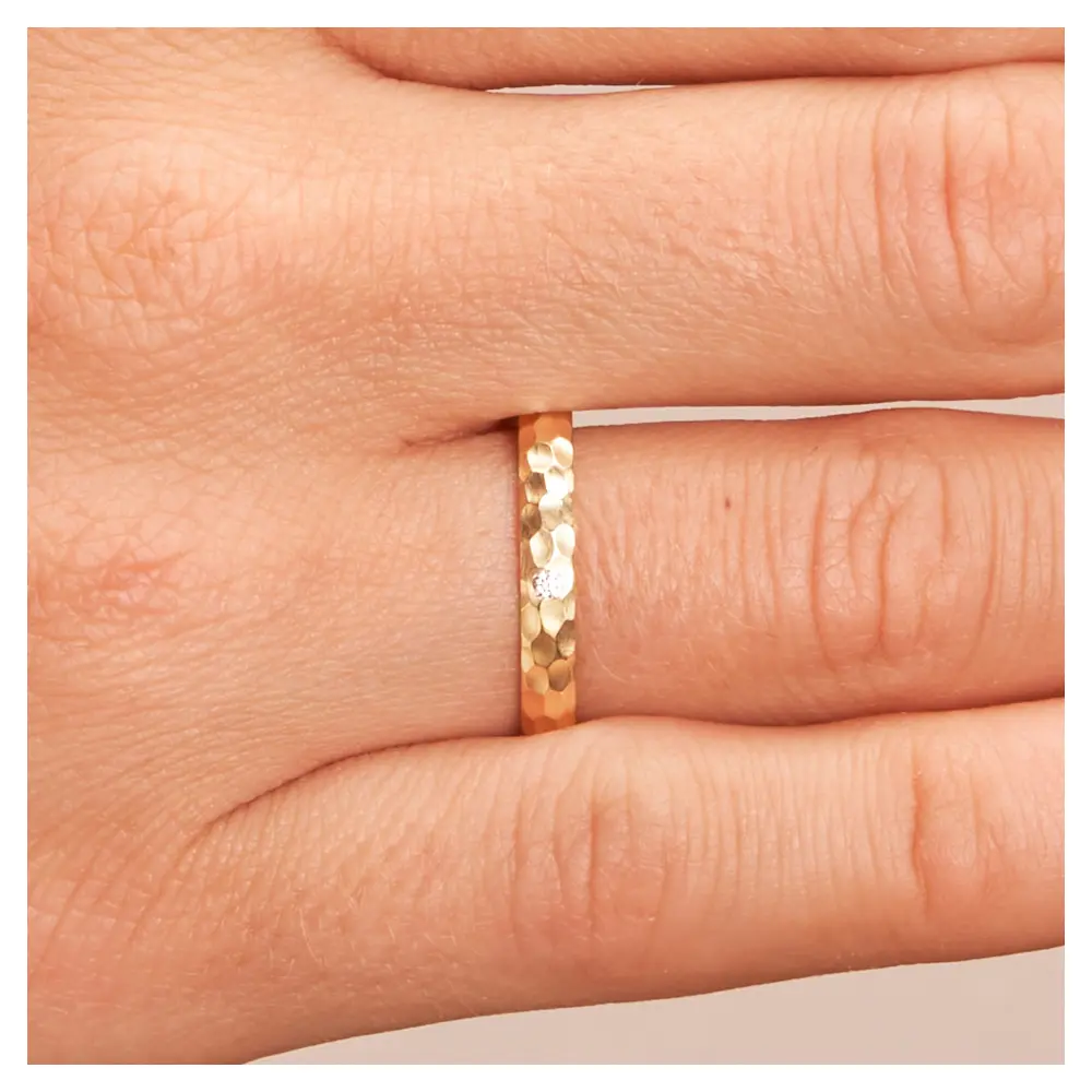 Gelbgold Eheringe in mattem Hammerschlag mit Diamanten auf Hand im Zoom