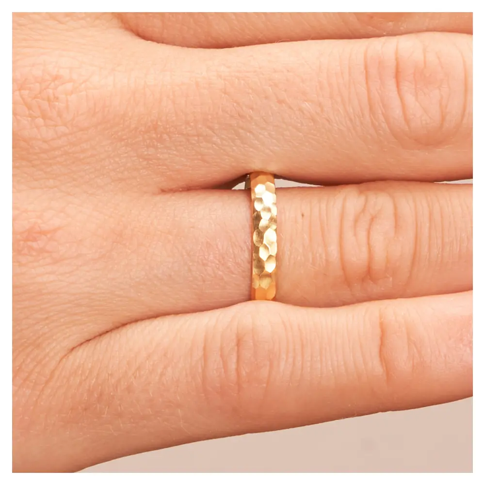 Gelbgold Eheringe in mattem Hammerschlag auf Hand im Zoom