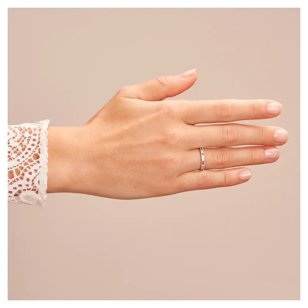 Eheringe aus rhodiniertem Silber 925 mit Zirkonia im Kanal und Strukturierung auf Hand