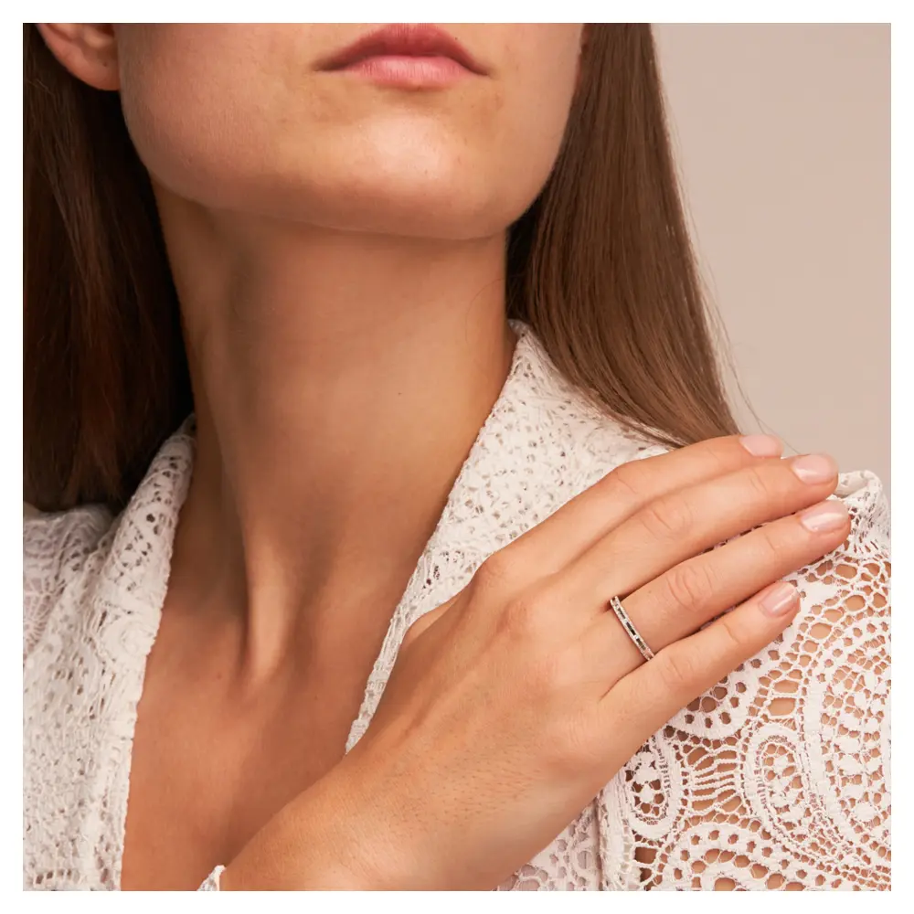 Eheringe aus rhodiniertem Silber 925 mit Zirkonia und Strukturierung auf Hand am Gesicht