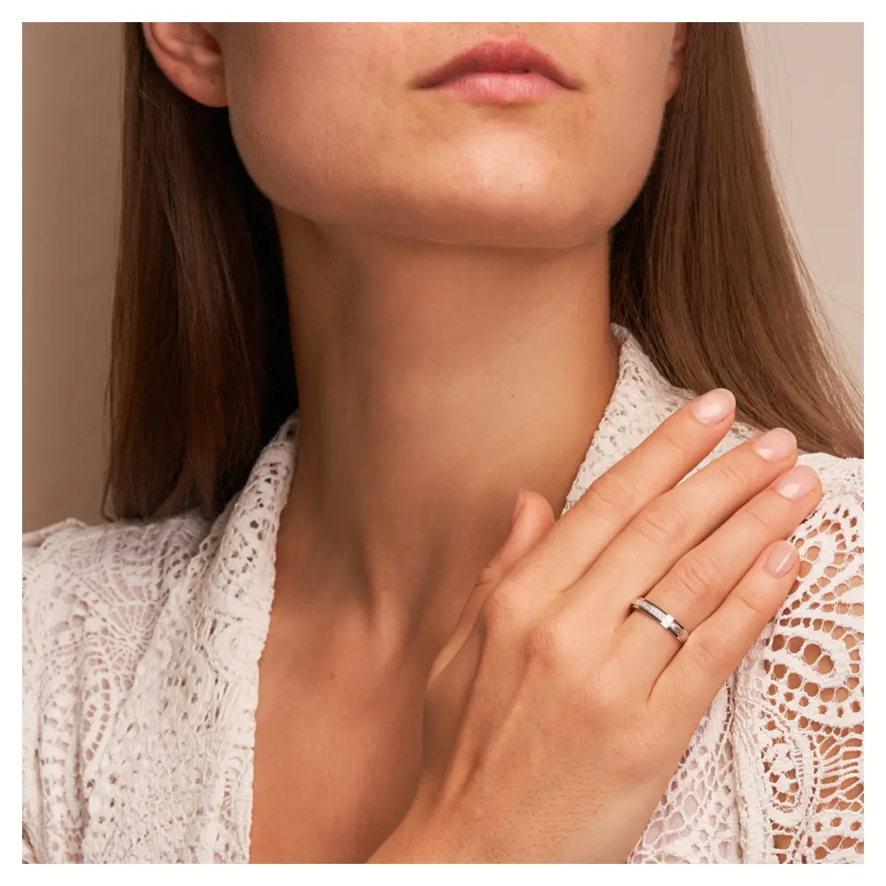 Eheringe aus rhodiniertem Silber 925 kratzmatt mit 12 Zirkonia auf Hand am Gesicht