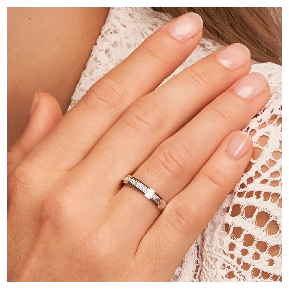 Eheringe aus rhodiniertem Silber 925 kratzmatt mit 12 Zirkonia auf Hand am Gesicht im Zoom