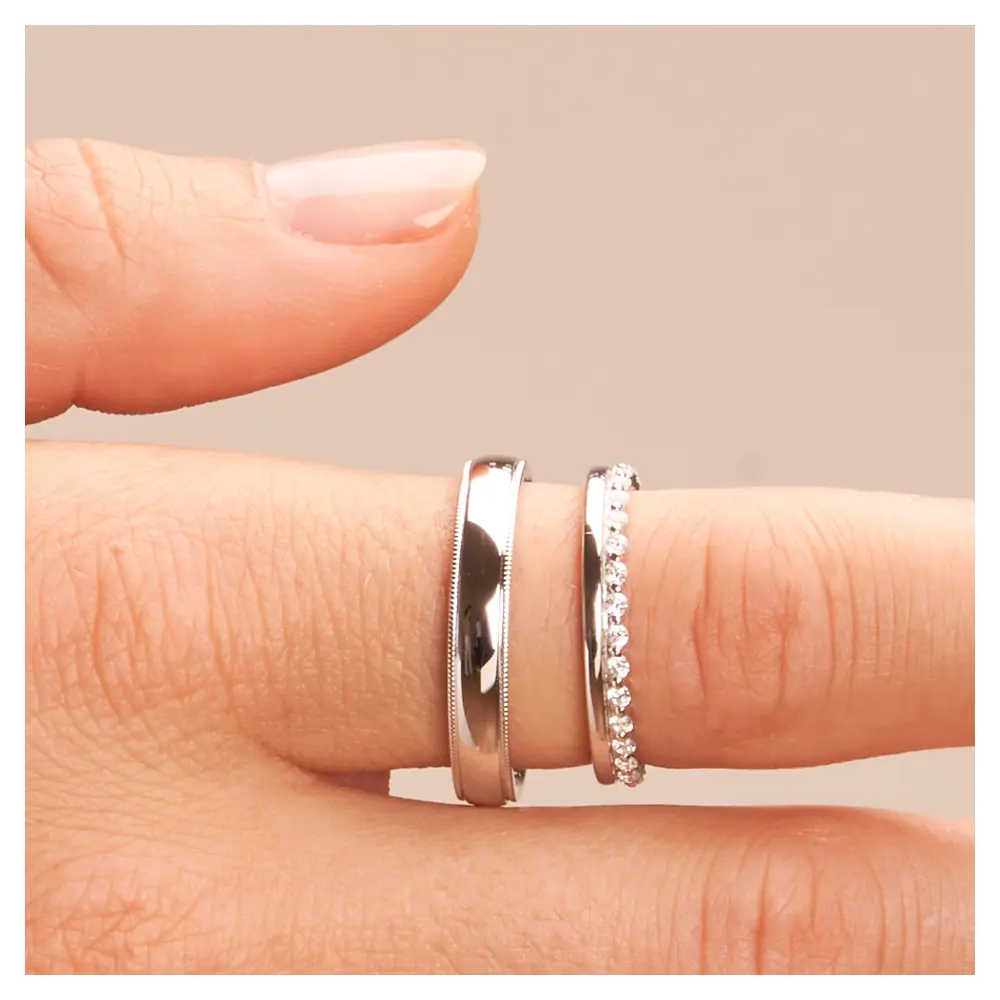 Polierte Eheringe aus rhodiniertem Silber 925 mit Zirkoniaband auf Finger im Zoom