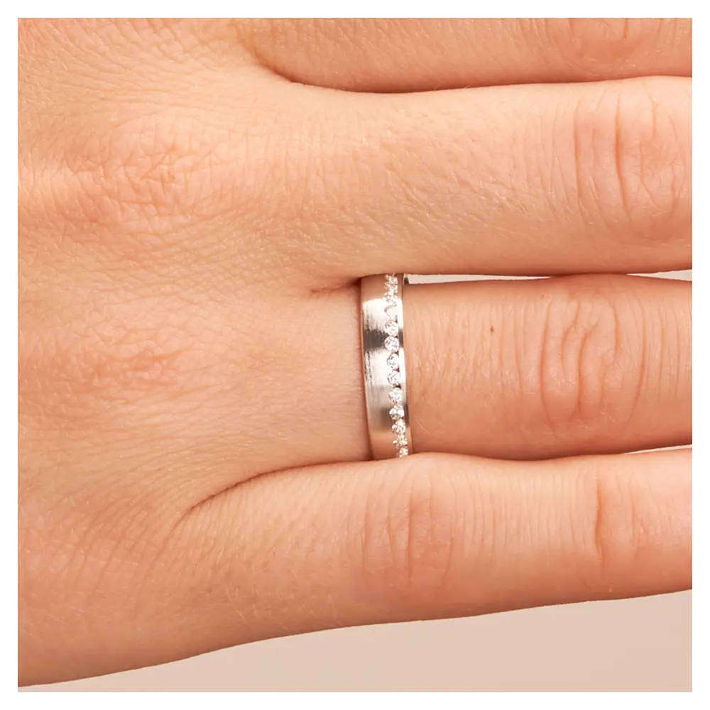 Mattierter Ehering aus rhodiniertem Silber 925 mit Band aus Zirkonia auf Hand im Zoom