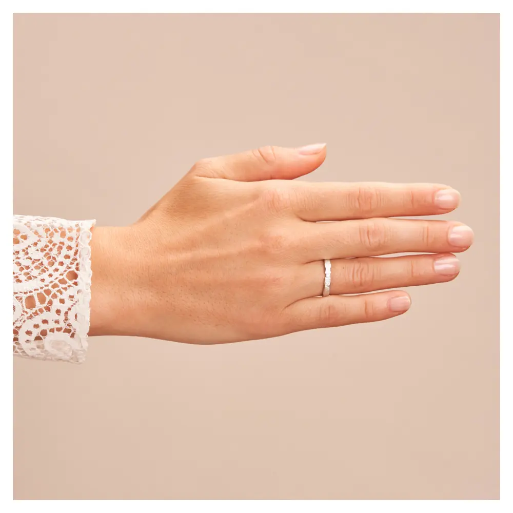 Eheringe aus rhodiniertem Silber 925 mit Zirkonia und Strukturierung auf Hand