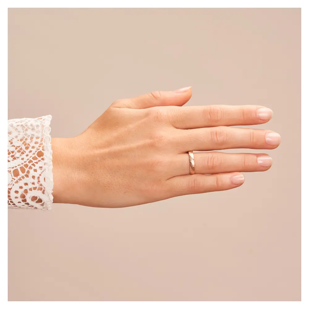Eheringe aus Roségold mit Hammerschlag und Diamanten auf Hand