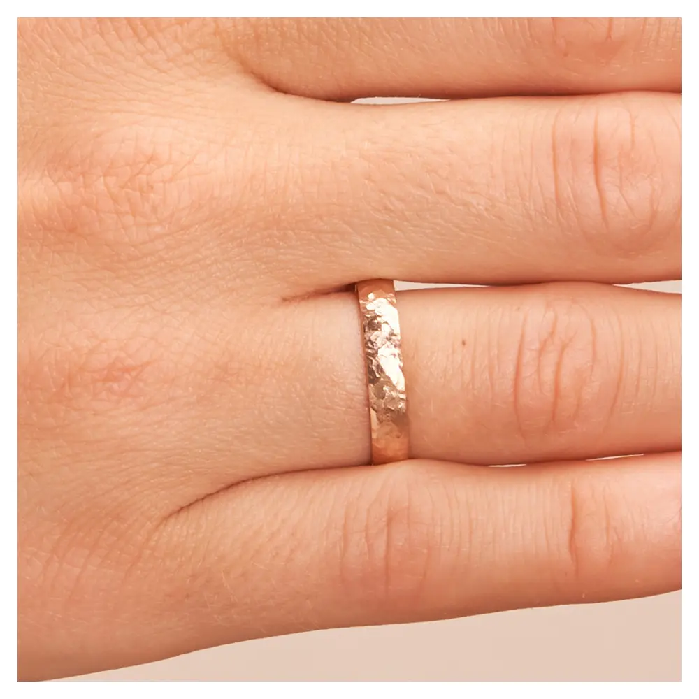Eheringe aus Roségold mit Hammerschlag auf Hand im Zoom