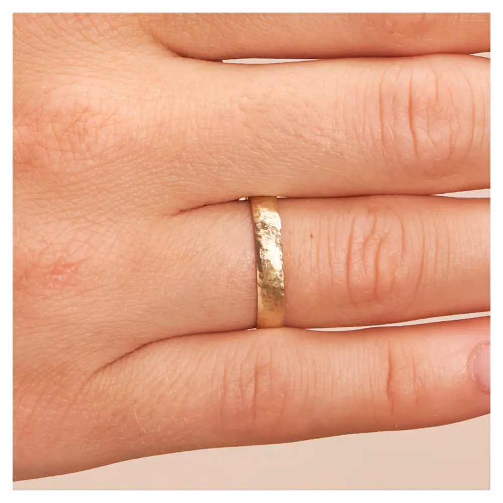 Gelbgold Ehering mit Hammerschlag auf Hand im Zoom