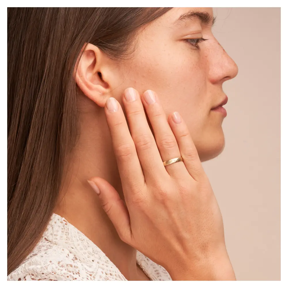 Gelbgold Eheringe mit Hammerschlag und Diamanten auf Hand