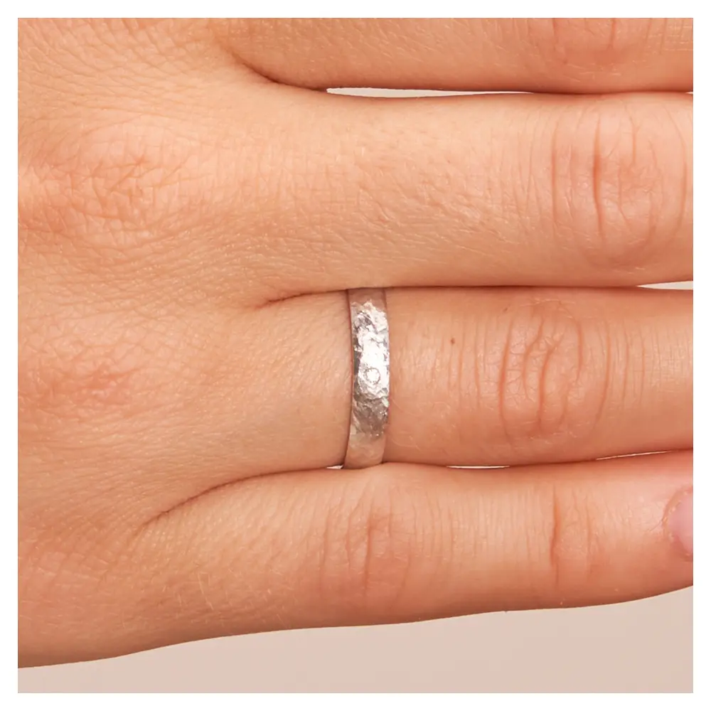 Ehering aus Weissgold in 3 mm mit Hammerschlag und Diamanten auf Hand im Zoom
