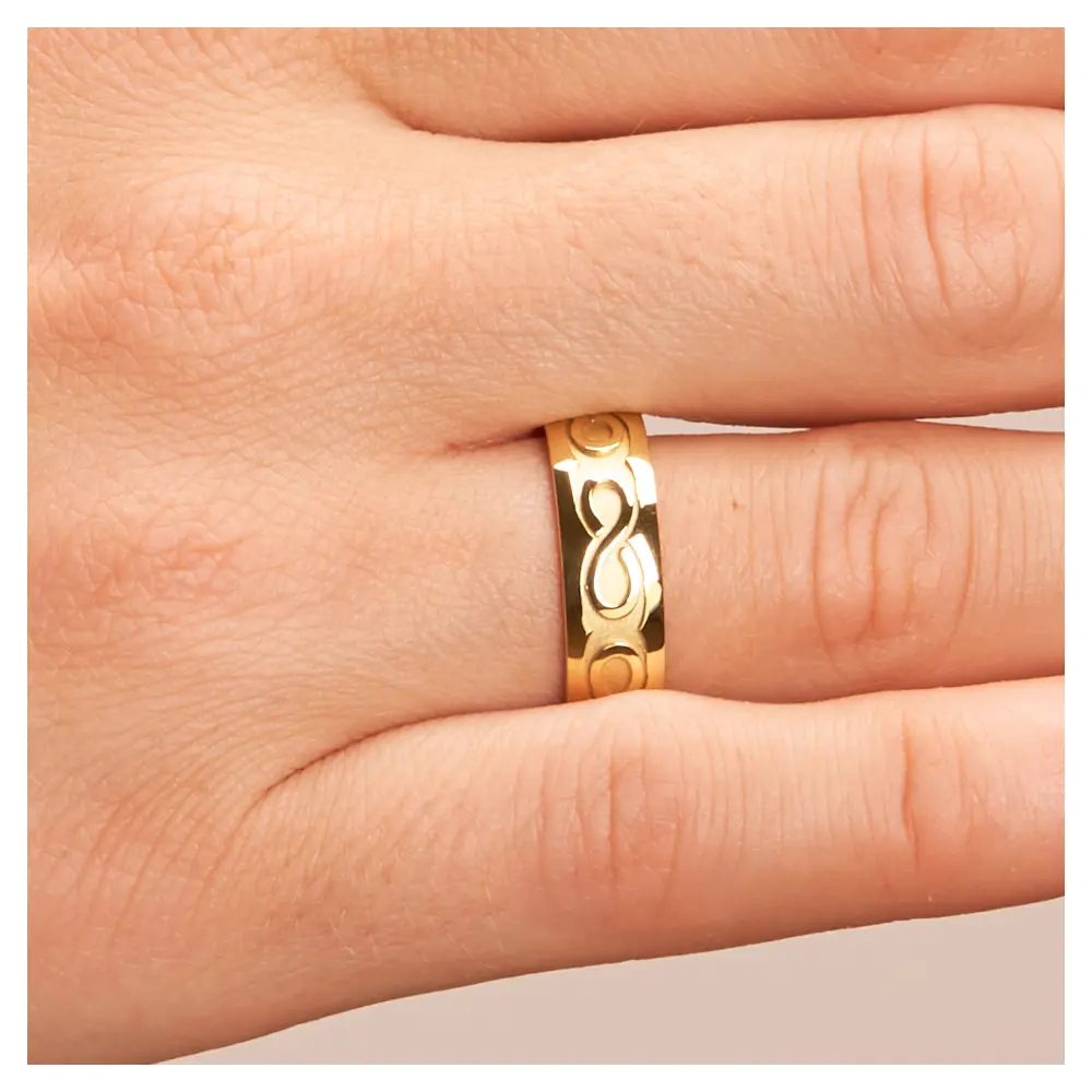 Gelbgold Eheringe mit Unendlichkeit-Zeichen in Sandmattierung auf Hand im Zoom