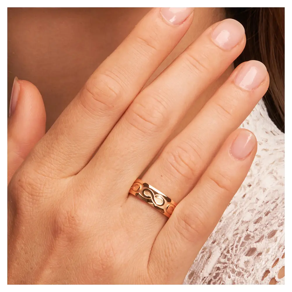 Rotgold Eheringe mit Unendlichkeit-Zeichen in Sandmattierung auf Hand am Gesicht im Zoom