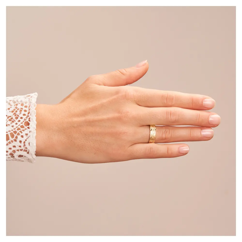 Gelbgold Trauringe mit sandmattem geometrischem Muster auf Hand