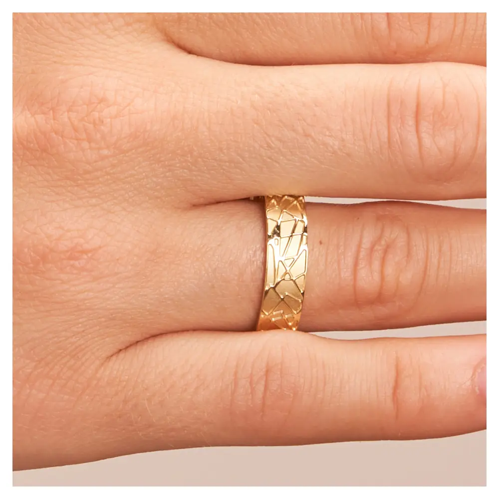 Gelbgold Trauringe mit sandmattem geometrischem Muster auf Hand im Zoom