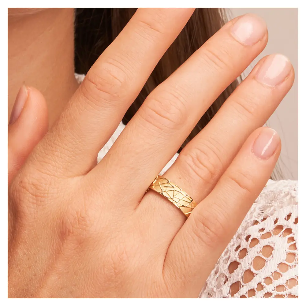 Gelbgold Trauringe mit sandmattem geometrischem Muster auf Hand im Gesicht im Zoom