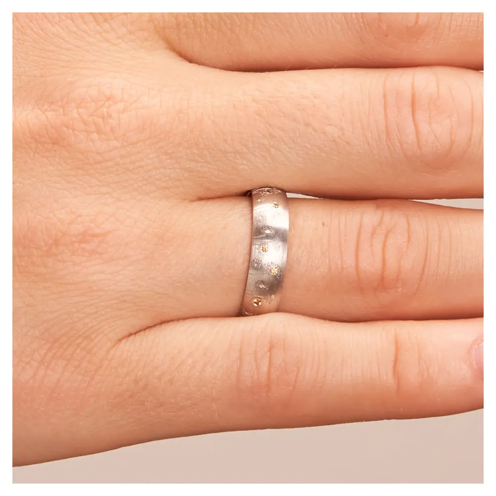 Weißgold Trauring mit Blumen als Dekor und vierzehn Diamanten auf Hand im Zoom