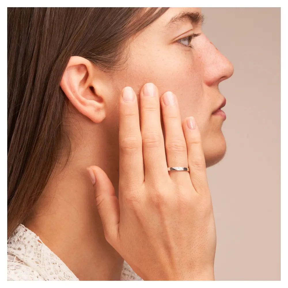 Weissgold Ehering mit Diamanten in 2,5 mm Breite auf Hand am Gesicht