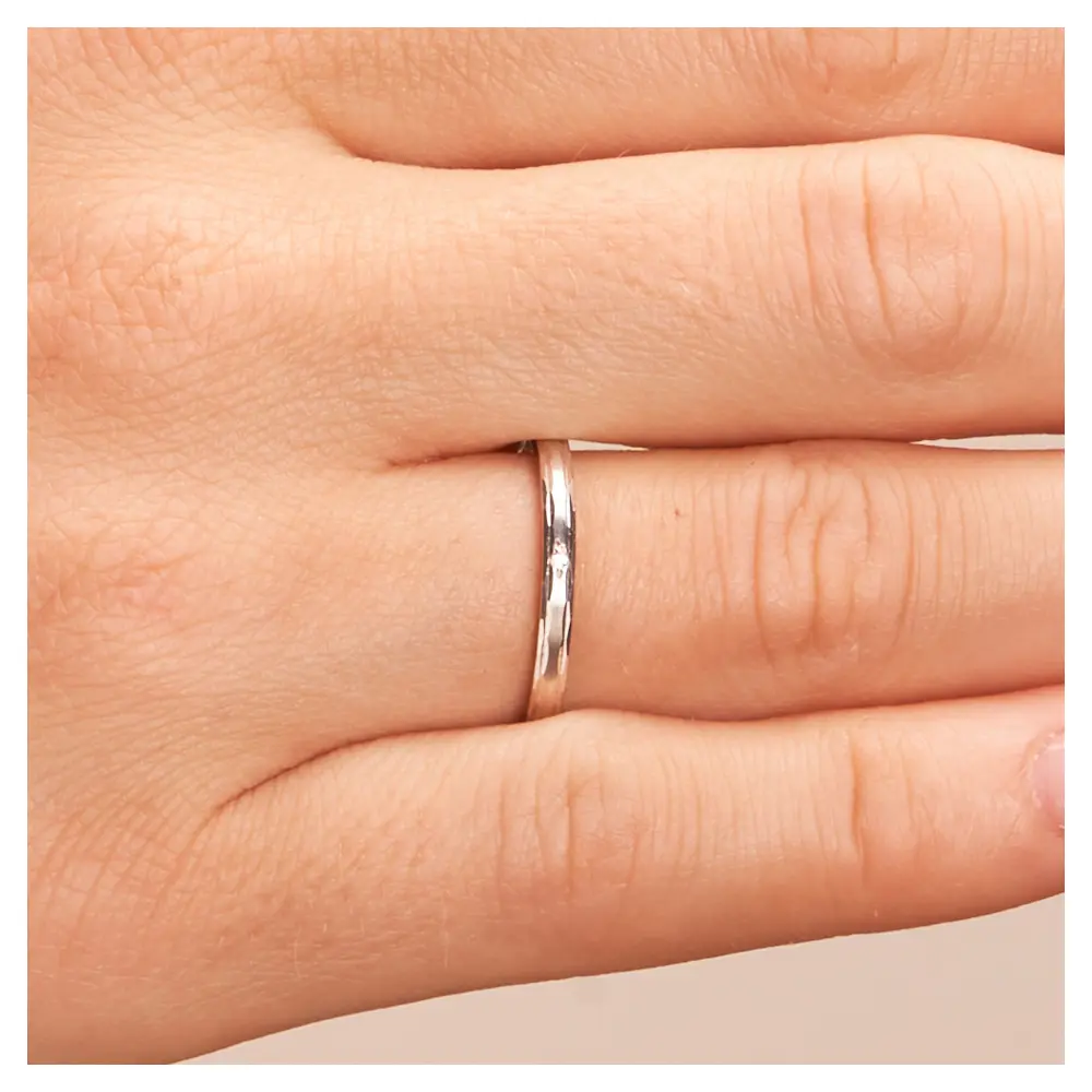Weißgold Trauringe 2 mm breit mit Randmuster und Diamant auf Hand im Zoom