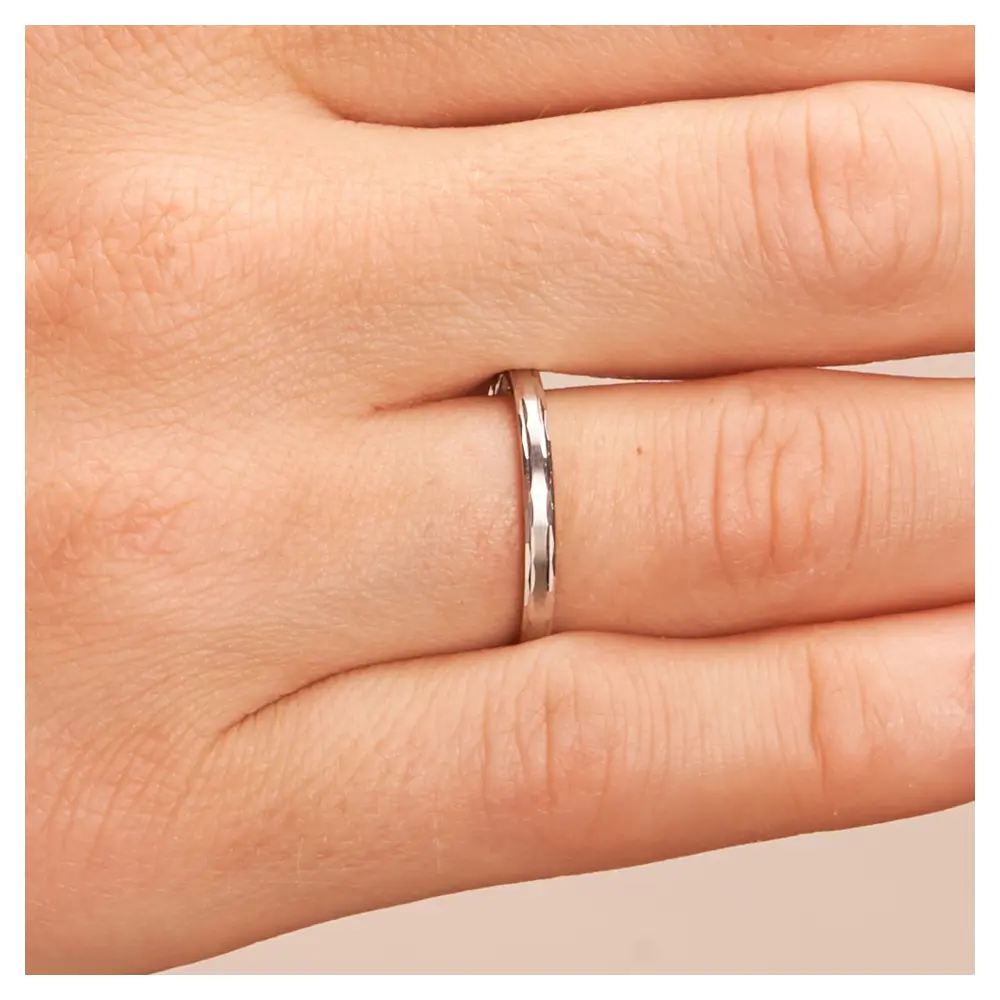 Platin Trauringe 2 mm breit mit Randmuster auf Hand im Zoom