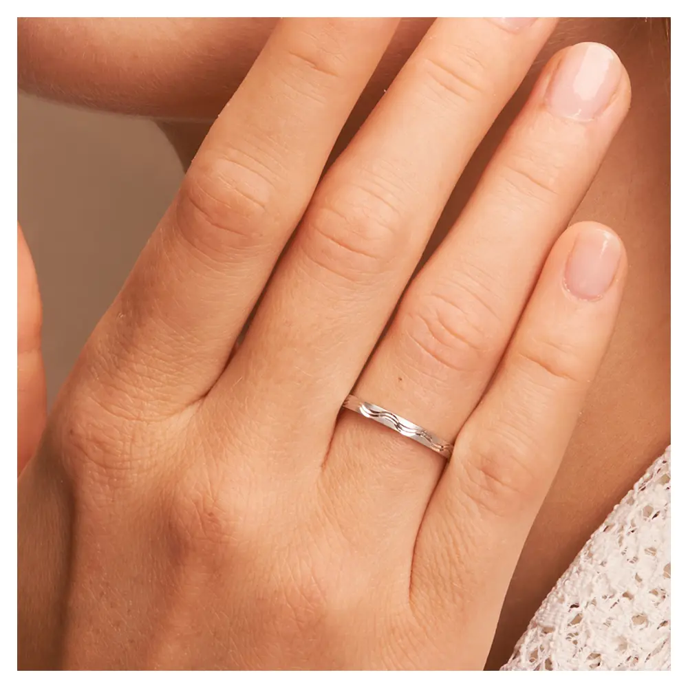 Platin Trauringe schmal mit Wellenmuster auf Hand am Gesicht im Zoom