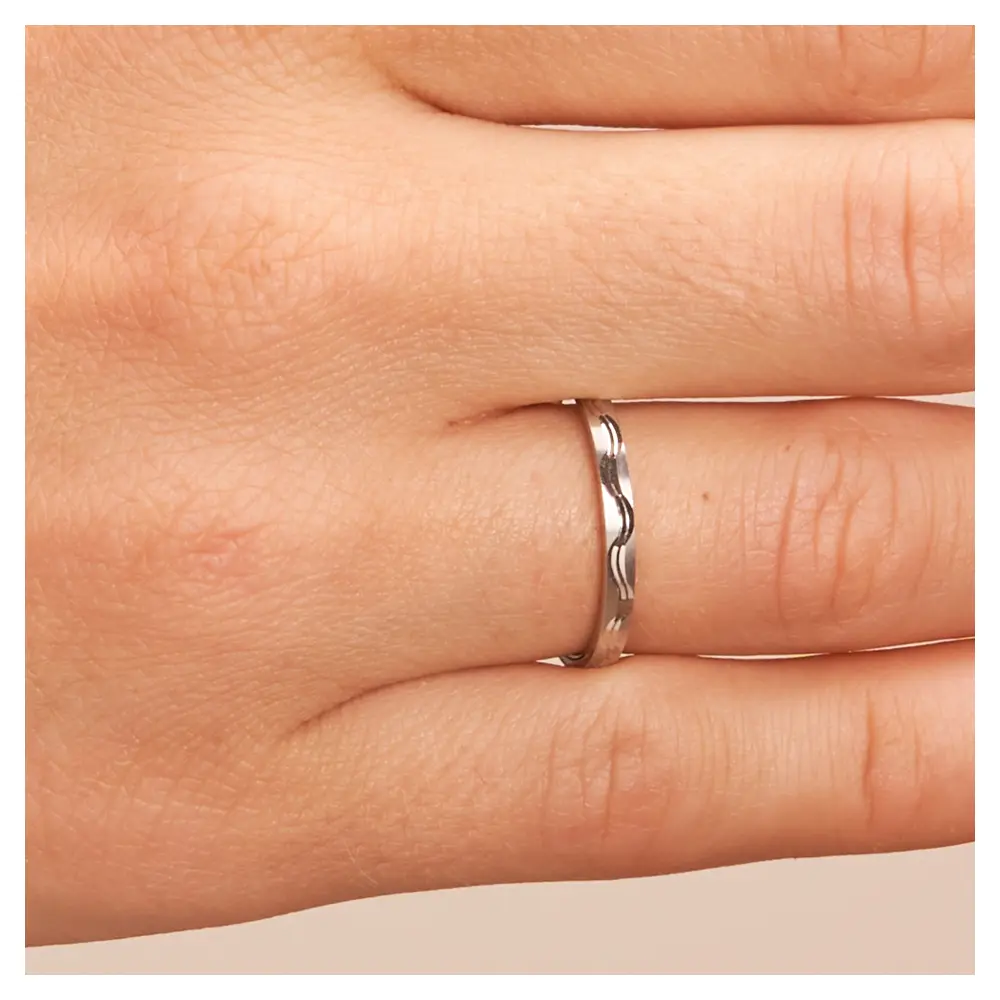 Platin Trauringe schmal mit Wellenmuster auf Hand im Zoom