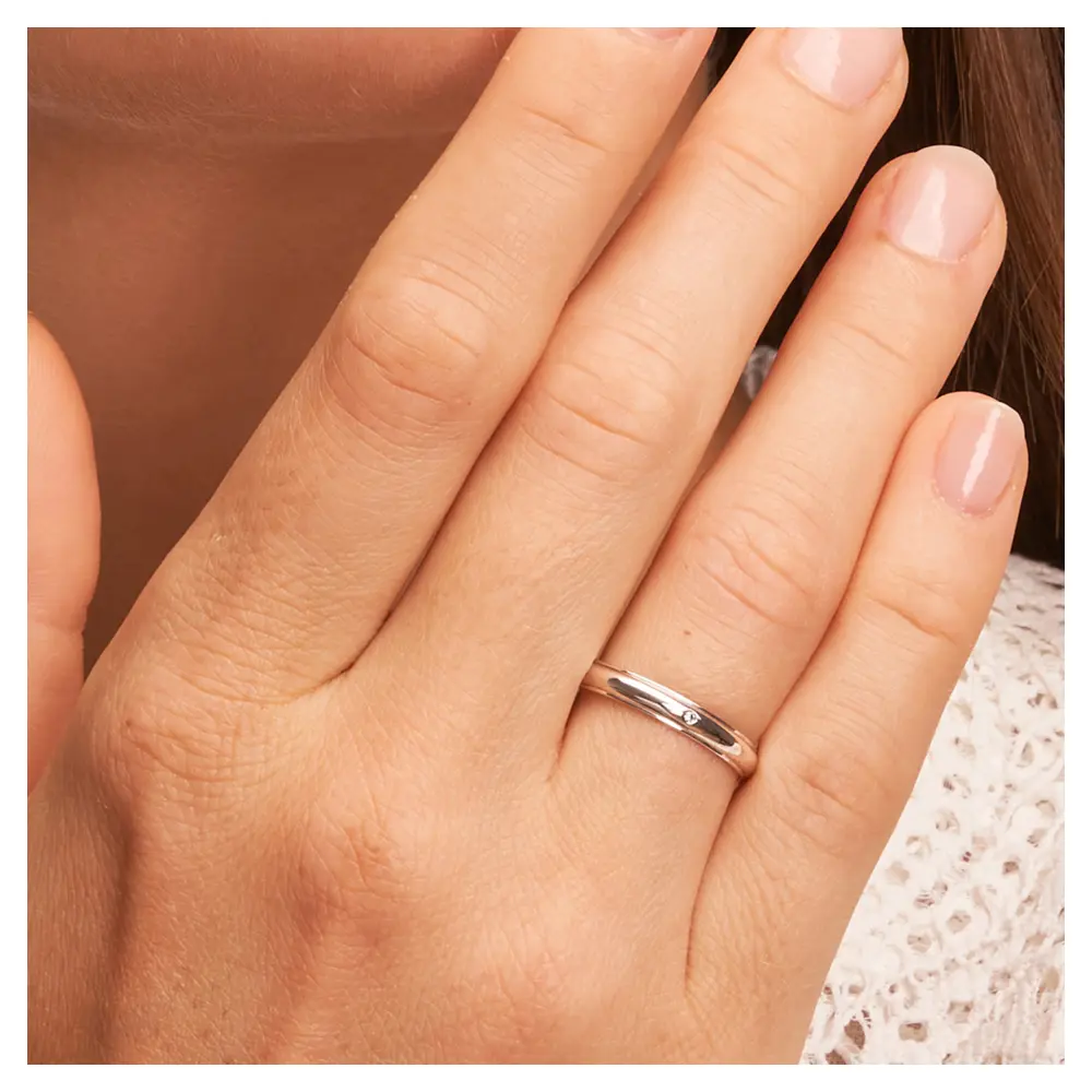 Weissgold Ehering 3 mm mit Polierung und Diamanten auf Hand am Gesicht im Zoom