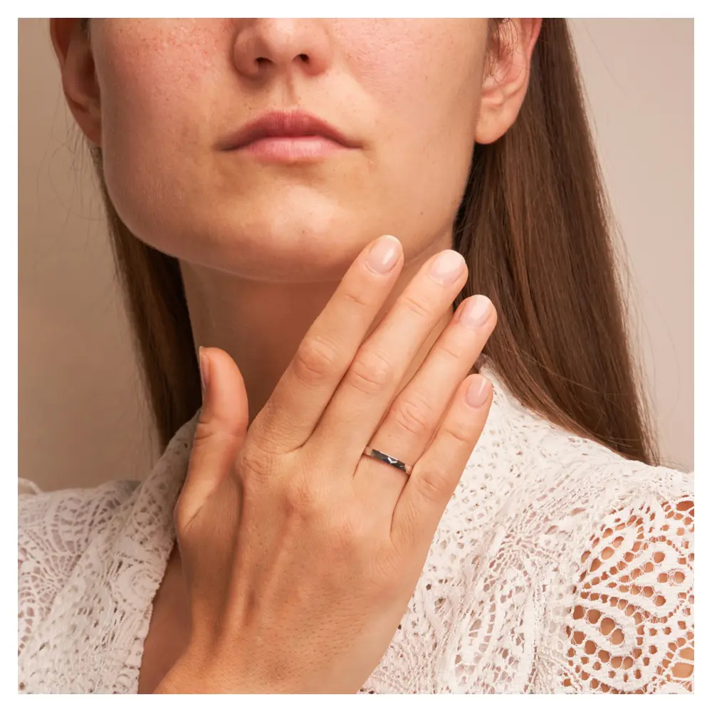 Platin Eheringe mit geometirschem Muster auf Hand am Gesicht