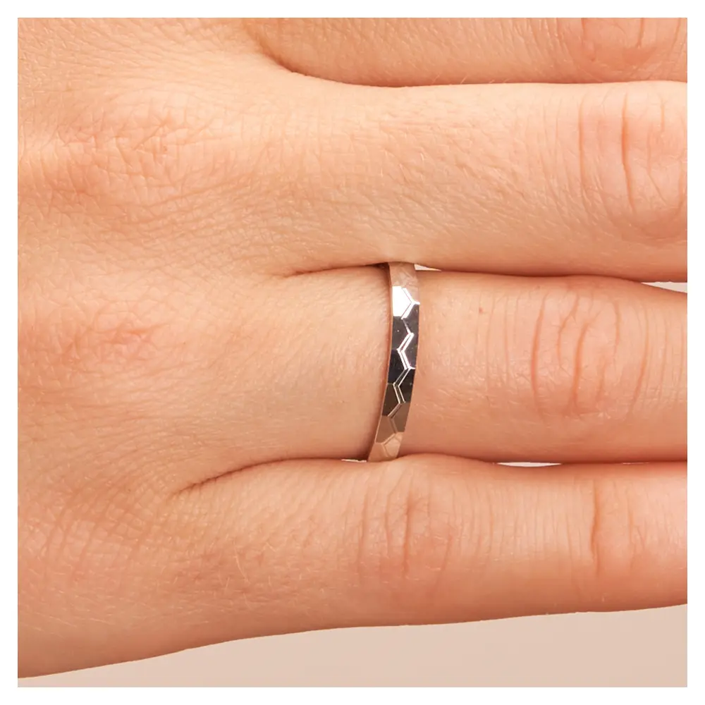 Platin Eheringe mit geometirschem Muster auf Hand im Zoom