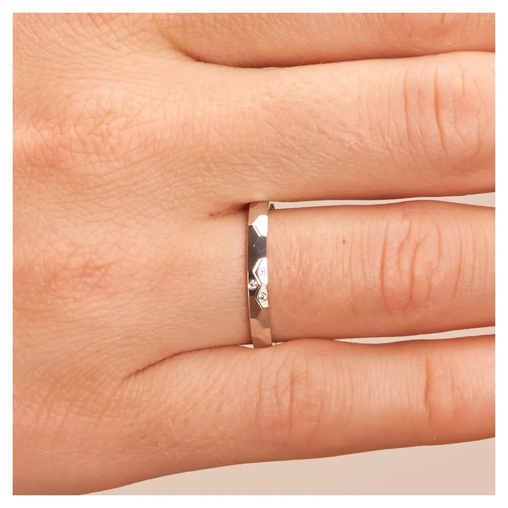 Platin Eheringe mit geometirschem Muster und 3 Diamanten auf Hand im Zoom