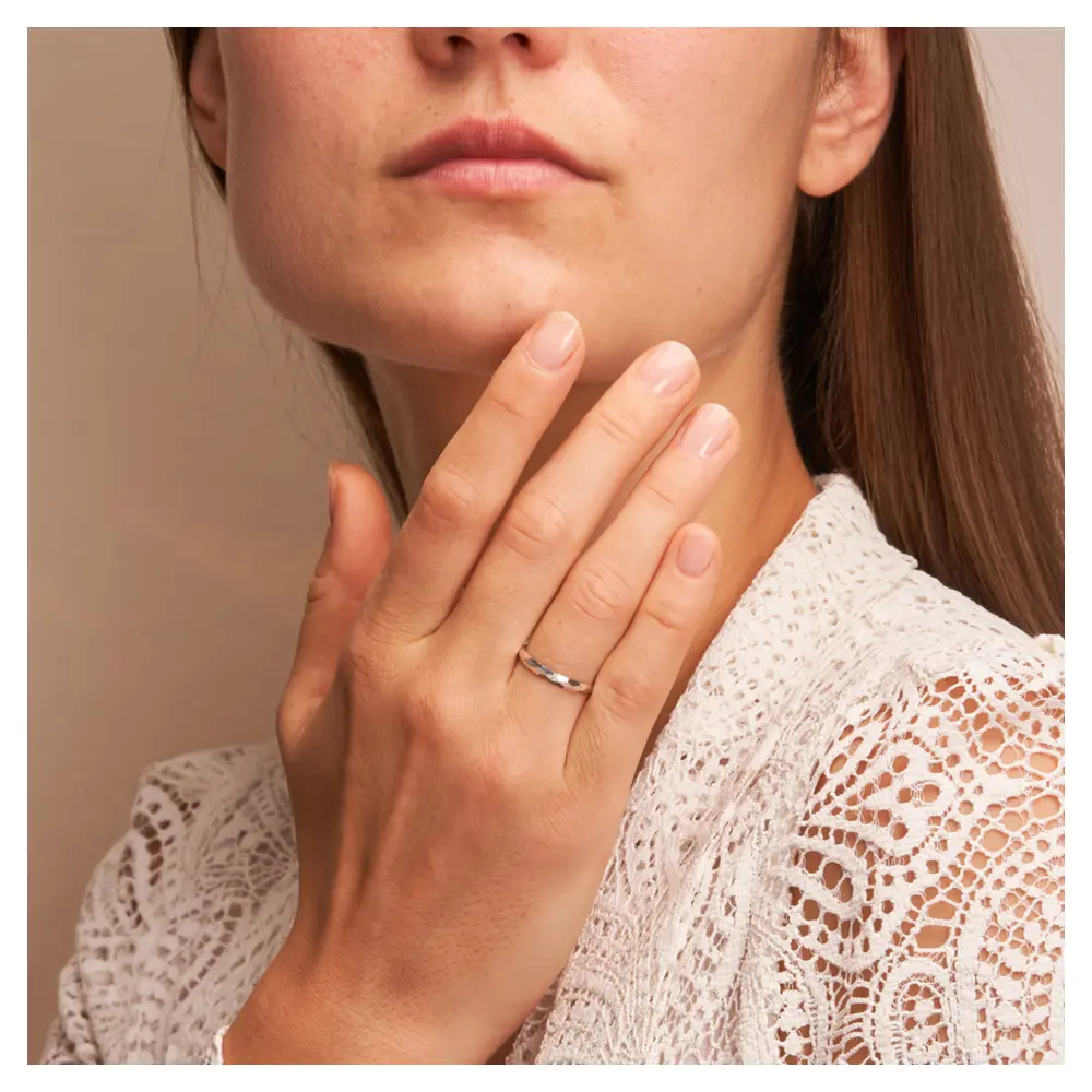 Weissgold Eheringe 2,5 mm breit mit Diamanten und Strukturierung auf Hand am Gesicht