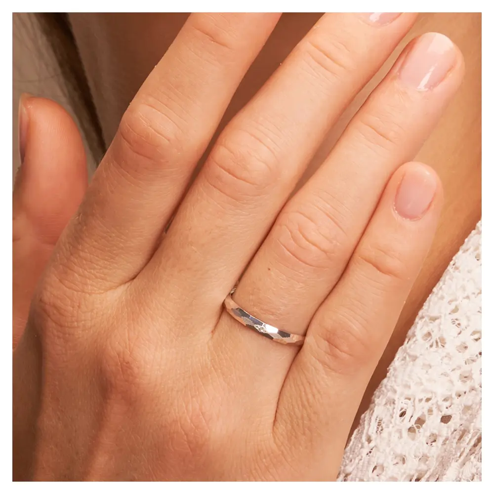 Weissgold Eheringe 2,5 mm breit mit Diamanten und Strukturierung auf Hand am Gesicht im Zoom