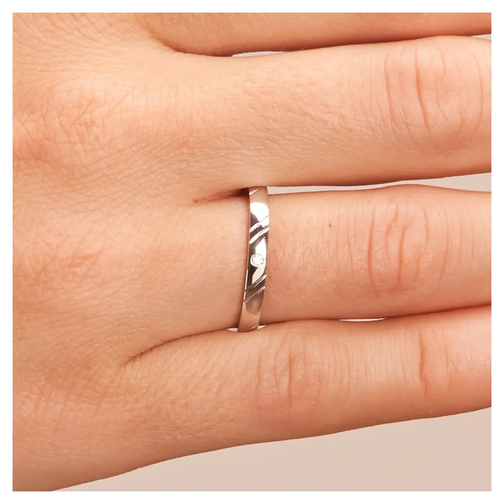 Platin Eheringe in 2,5 mm Breite mit Rillenmuster und Diamanten auf Hand im Zoom