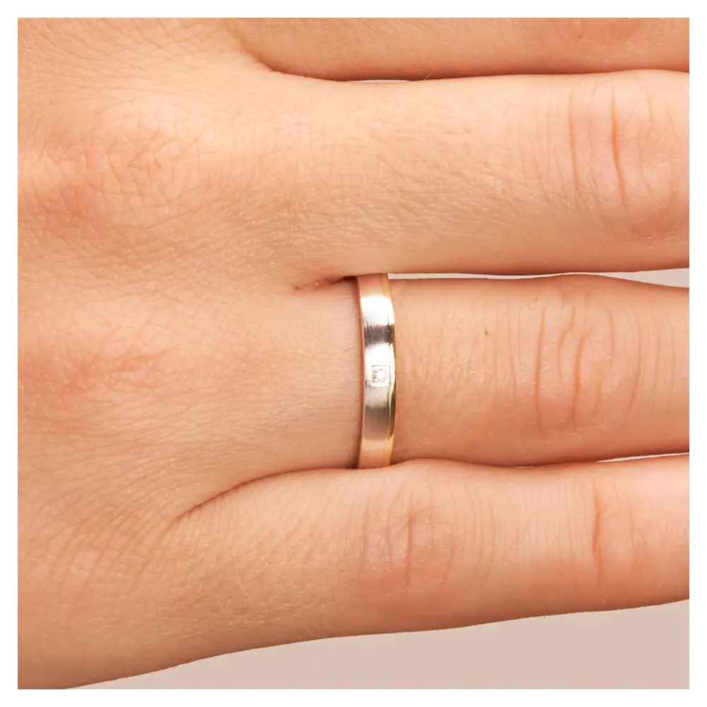 Gelbgold und Weissgold Ehering mit Diamanten und Mattierung auf Hand im Zoom