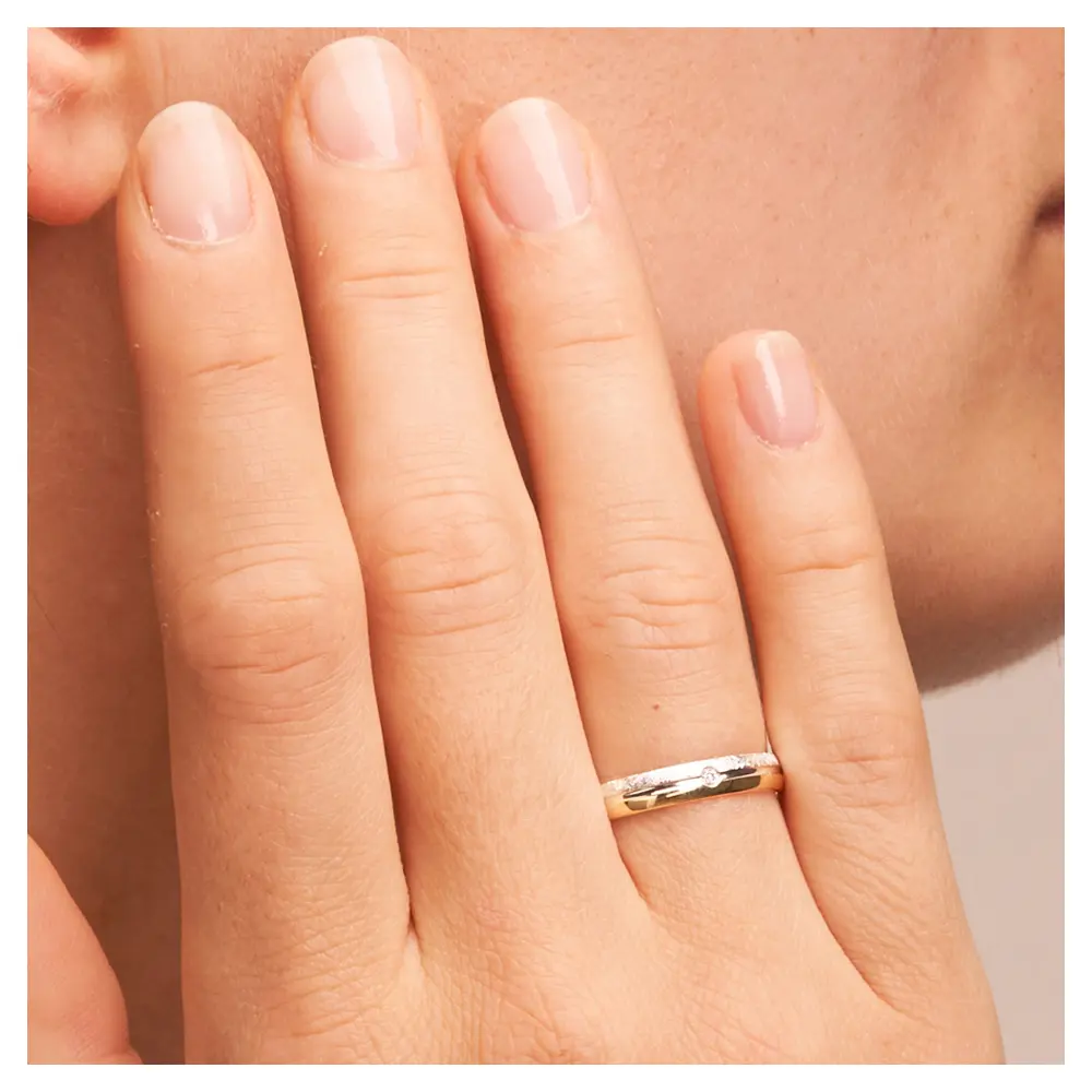 Gelbgold und Weissgold Ehering mit Querbürstung und Polierung und Diamanten auf Hand im Zoom