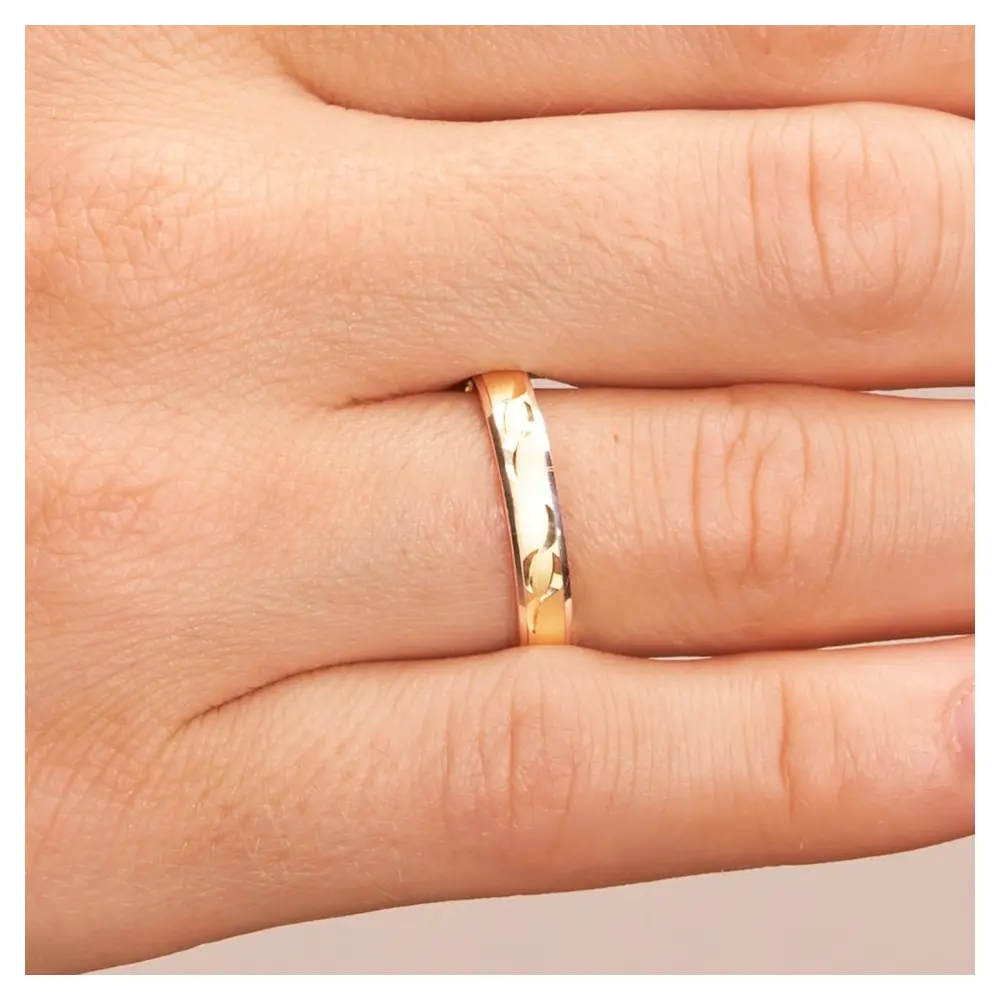 Gelbgold und Weissgold Ehering mit Sichelmustern auf Hand im Zoom
