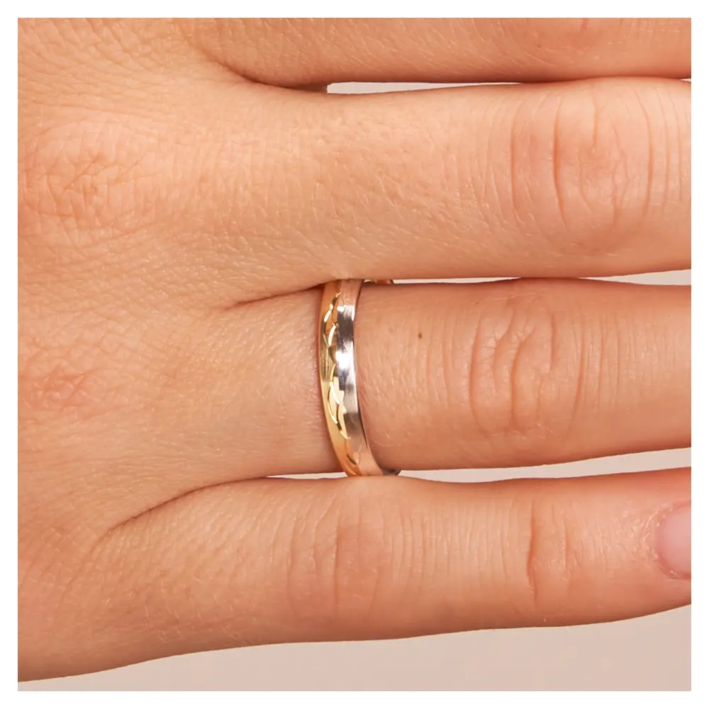 Gelbgold und Weissgold Ehering mit Muster aus polierten Halbmonden auf Hand im Zoom