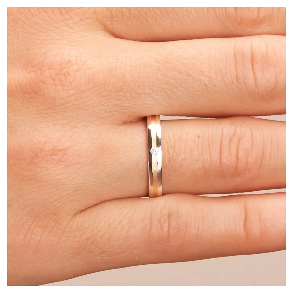 Gelbgold und Weissgold Ehering mit Diamanten und sandmattem Mittelstreifen auf Hand im Zoom