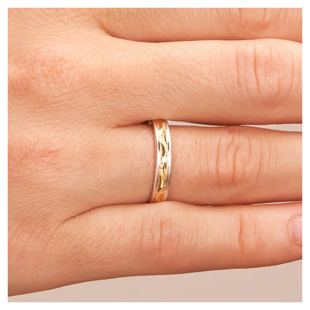 Gelb-&Weissgold Eheringe mit Mustern aus Kreisen und Halbmonden und Diamant auf Hand im Zoom