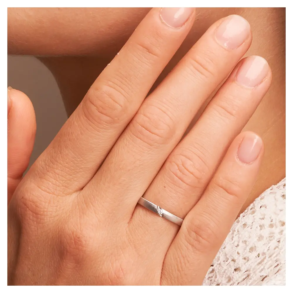 Palladium 500 Ehering mit Quermattierung und Diamanten auf Hand im Zoom