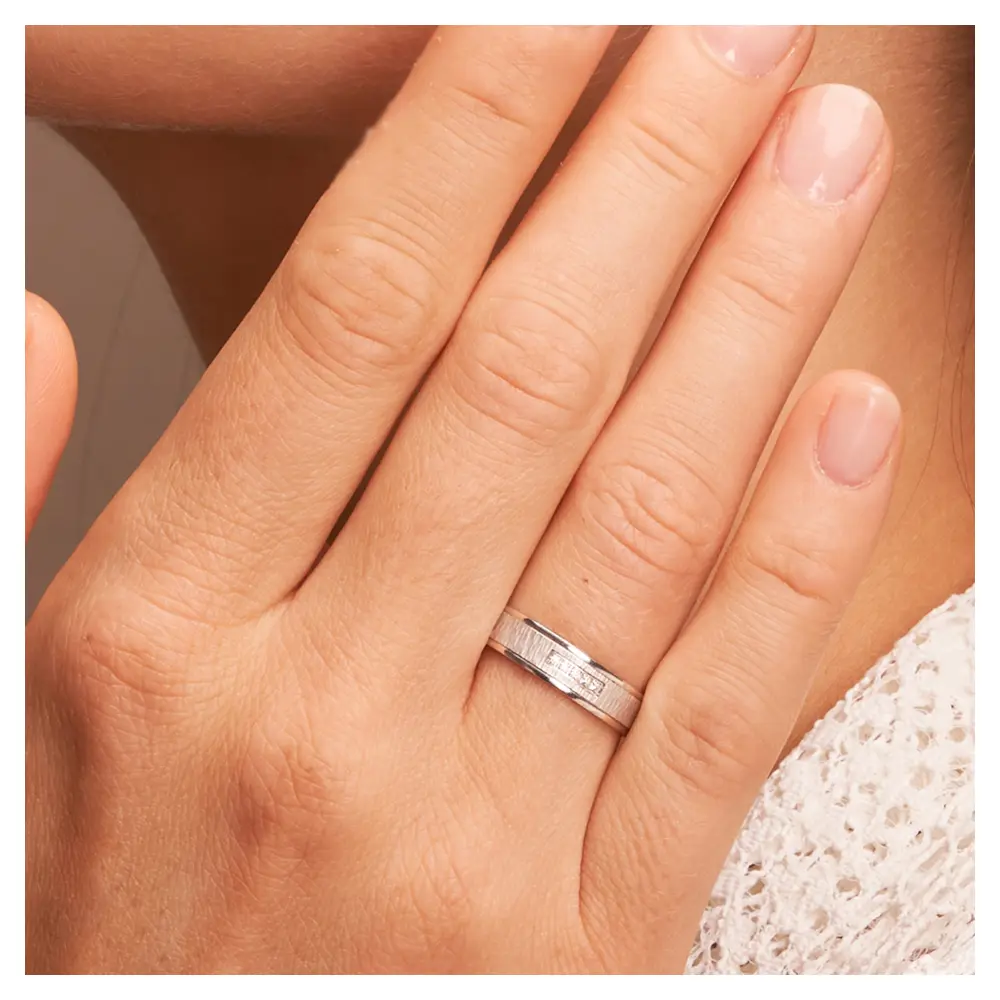 Weissgold Eheringe mit Diamanten und matter Strukturierung auf Hand im Zoom