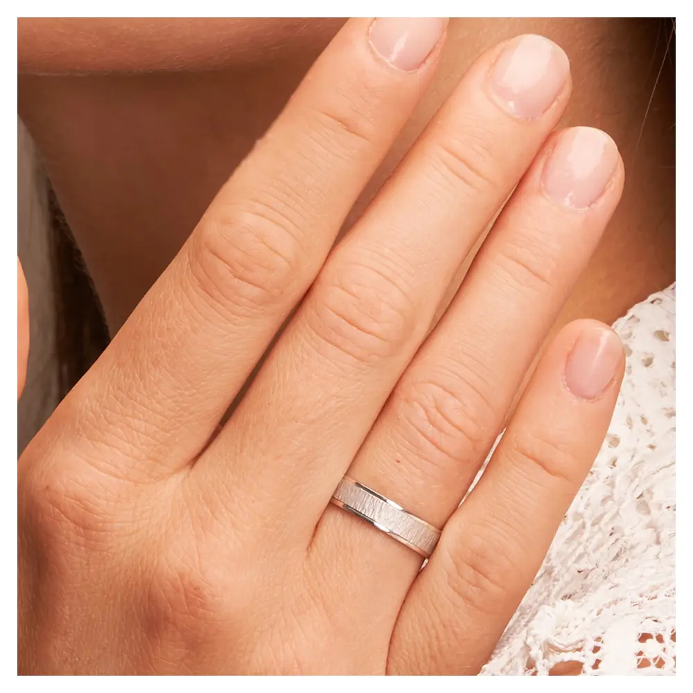 Weissgold Eheringe mit matter Strukturierung auf Hand im Zoom