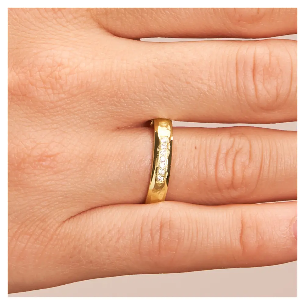 Eheringe aus Gelbgold mit 7 Diamanten und poliertem Hammerschlag auf Hand im Zoom