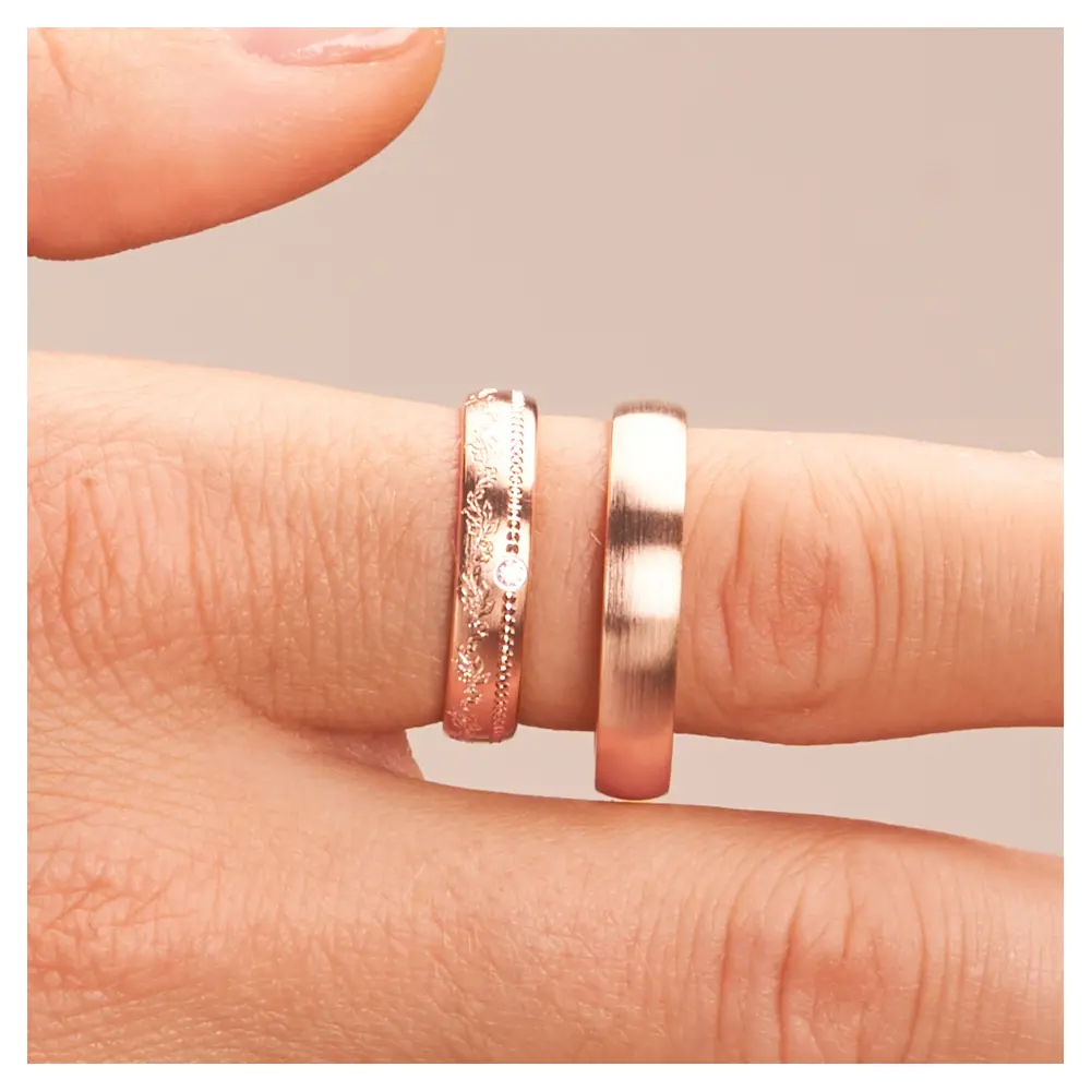 Roségold Eheringe mit Diamanten und blumigem Muster im Damenring auf Finger